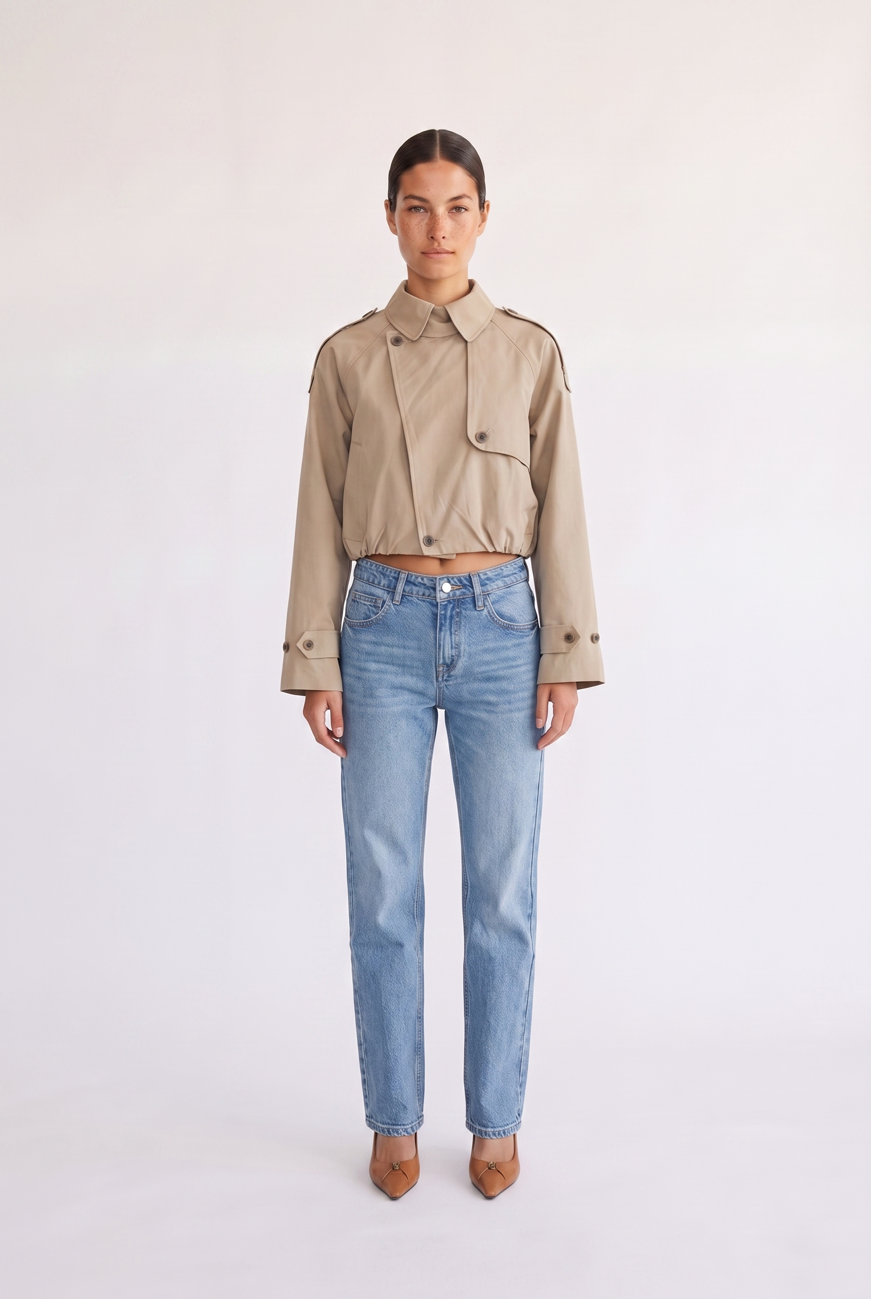 Woman wearing the Darcy tan cropped trench coat, front view