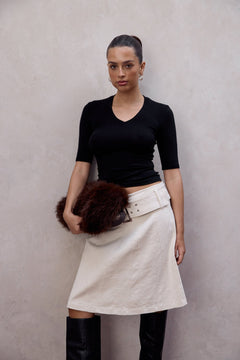 Woman wearing the Tess black ribbed v-neck top, front view