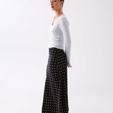 Model styling the Inez black polka dot slip skirt with a knit top